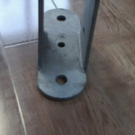 Back view of transformer mounting bracket revealing welded reinforcement ribs and hinge